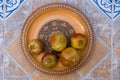 Pomegranates on pattered wooden plate. Tiles