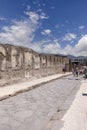 View of one of the city streets with group of tourists in ruins of ancient city, Pompeii, Naples, Italy Royalty Free Stock Photo