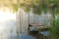 Pond in a city park with a bridge for fishermen. Reflection of houses in the water Royalty Free Stock Photo