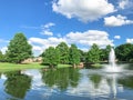 Pond with cloud reflection and water fountain in small American neighborhood