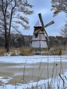 A pond covered with ice and covered with snow in Kalety Zielona, Poland. Visible windmill on the island Royalty Free Stock Photo