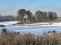 A pond covered with ice and covered with snow in Kalety Zielona, Poland. Visible windmill on the island Royalty Free Stock Photo