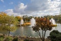 Pond with island with reeds and fountains in autumn park Royalty Free Stock Photo