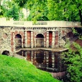 Pond with old beautiful stone grotto in summer park Royalty Free Stock Photo