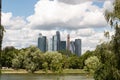 Pond in the park, green trees and shrubs, Moscow City skyscrapers, people on the embankment. Royalty Free Stock Photo