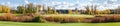 Pond with reeds among glade in autumn park, wide panorama Royalty Free Stock Photo