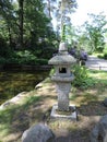 Pond. stone birdhouse, blooming bushes in the park, in Kotka, Finland