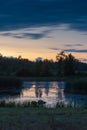 Pond Sunset Reflection with Dark Clouds and Orange Sky Royalty Free Stock Photo