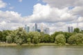 Pond, trees in the park, Moscow City skyscrapers, people on the embankment, cloudy sky. Royalty Free Stock Photo