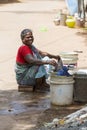 Indian poor woman wash clothes in street rural village