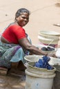 Indian poor woman wash clothes in street rural village