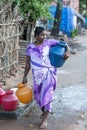 Indian poor woman wash clothes in street rural village