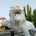 Ponorogo 11 September 2023 White lion statue in Ponorogo square in the afternoon, trees and buildings, blue sky