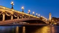 Pont Alexandre III bridge illuminated in evening with the Seine River. Paris, France Royalty Free Stock Photo