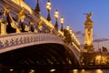 Pont Alexandre III Bridge and illuminated lamp posts at sunset. Paris, France