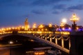 Pont Alexandre III Bridge and illuminated lamp posts at sunset with view of the Invalides. 7th Arrondissement, Paris, France Royalty Free Stock Photo