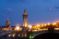 Pont Alexandre III Bridge and illuminated lamp posts at sunset with view of the Invalides. 7th Arrondissement, Paris Royalty Free Stock Photo