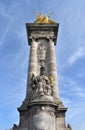 Pont Alexandre III detail. Concrete pillar counterweight with Louis XIV statue and gilded Fame sculpture on top. Paris, France. Royalty Free Stock Photo