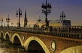 Pont de Pierre bridge and motion blur of tram in Bordeaux at sunset as the night sky scene Royalty Free Stock Photo