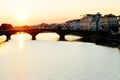 The Ponte Santa Trinita over Arno river at sunset, seen from Ponte Vecchio in Florence. .