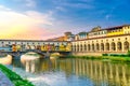 Ponte Vecchio bridge with colourful buildings houses over Arno River reflecting water in Florence