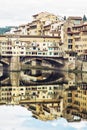 Ponte Vecchio and historic buildings are mirrored in the river A Royalty Free Stock Photo