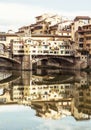 Ponte Vecchio and historic buildings are mirrored in the river A Royalty Free Stock Photo