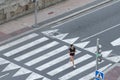 A woman crosses a crosswalk