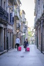 A couple of travelers drag their red suitcases.