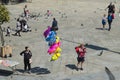 A young Gypsy woman sells colored balloons