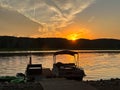 Pontoon boat moored at pier during Mississippi River sunset Royalty Free Stock Photo