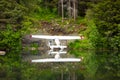 A pontoon plane reflected in a calm lake at seward