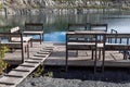 Pontoon with a wooden table and benches for relaxation is on the blue water of the lake Royalty Free Stock Photo