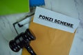 Ponzi Scheme text on document above brown envelope