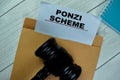 Ponzi Scheme text with document brown envelope and gavel isolated on office desk