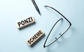 PONZI SCHEME text on wooden block ,blue background Royalty Free Stock Photo