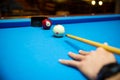 Pool balls on the blue felt pool table with player hands and pool cue stick. Indoor sports. sport and gambling concept. Royalty Free Stock Photo