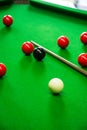 some pool balls, cues and a cue standing on the pool table Royalty Free Stock Photo
