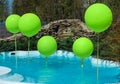 Pool with big green balloons outdoor. Poolside party. The balloons on water. Decorations for wedding ceremony by the pool Royalty Free Stock Photo