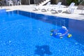 Pool with blue water ladder for descent and ascent into the water. The sun loungers are empty by the pool