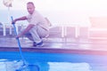 Hotel staff worker cleaning the pool. Maintenance.