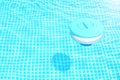 Pool cleaning chemicals background. Floating chlorine tablet dispenser for pools lies in water