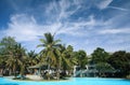 Pool with coconut palms and clouds Royalty Free Stock Photo