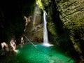 Waterfall inside a cave, green pool of water. Kozjak waterfall, Soca river, Slovenia. Royalty Free Stock Photo