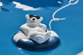 Pool decoration in the form of a relaxed bathing polar bear with sunglasses and a swim ring
