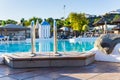 at the pool edge at resort hotel with ladder into the water besides some rocks