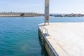 Pool ladder on a white marble pier in front of a sign forbidden to climb the tower due to danger of electrocution