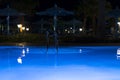 Pool lighting in backyard at night for family lifestyle and living area. Luxury design with good light and clean landscaping. pool Royalty Free Stock Photo