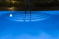 Pool lighting in backyard at night for family lifestyle and living area. Luxury design with good light and clean landscaping. pool Royalty Free Stock Photo