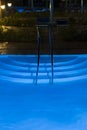 Pool lighting in backyard at night for family lifestyle and living area. Luxury design with good light and clean landscaping. pool Royalty Free Stock Photo